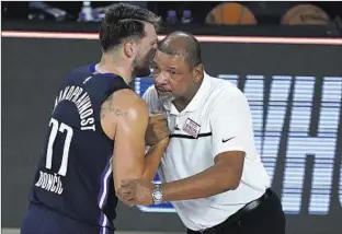  ?? Ashley Landis Getty Images ?? DOC RIVERS, coach of the Clippers, forgoes social distancing and other protective measures as he greets Dallas’ Luka Doncic after a game. But the NBA’s bubble has been a safe haven.