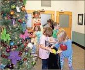  ?? Kenya Hunter ?? Clementine Walker (left) and Evy Molnar, third graders at Berry Elementary and Middle School, stuff a trash bag with gifts before they take it out to Janet Baltzer’s van so they can be donated to Angel Express.