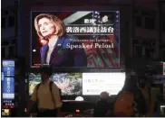  ?? CHIANG YING-YING — THE ASSOCIATED PRESS ?? People walk past a billboard welcoming Nancy Pelosi in Taipei, the capital of Taiwan, on Tuesday