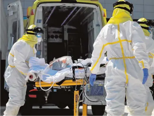  ??  ?? Varios sanitarios trasladan en Madrid a un paciente crítico de Covid durante la primera ola de la pandemia