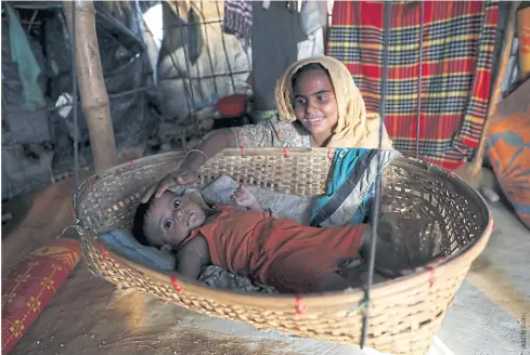  ??  ?? Rafia, a Rohingya refugee mother, plays with her son inside a shelter at the Jamtoli refugee camp in Cox’s Bazar, Bangladesh.