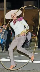  ?? [PHOTOS BY WHITNEY BRYEN, FOR THE OKLAHOMAN] ?? A performer does tricks with a lasso along the Norman Christmas Parade route.