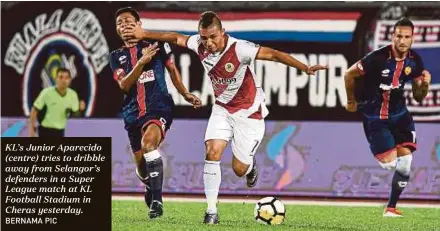  ?? BERNAMA PIC ?? KL’s Junior Aparecido (centre) tries to dribble away from Selangor’s defenders in a Super League match at KL Football Stadium in Cheras yesterday.