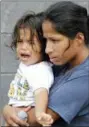  ?? AP PHOTO/DAVID J. PHILLIP ?? Nineteen-month-old Jesus Funes cries as his mother, Diva Funes, both immigrants from Honduras, holds him after being escorted back to Reynosa, Mexico, Thursday. The family, who was seeking asylum, said they were told by officials they would be separated, so they voluntaril­y returned to Mexico.