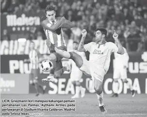  ?? — Gambar AFP ?? LICIK: Griezmann (kiri) melepasi kekangan pemain pertahanan Las Palmas, Aythami Artiles pada perlawanan di Stadium Vicente Calderon, Madrid pada Selasa lepas.