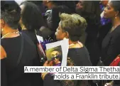  ??  ?? A member of Delta SIgma Thetha holds a Franklin tribute.