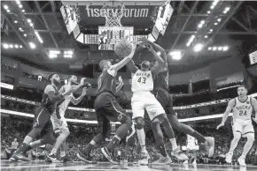  ?? ?? The Bucks' Thanasis Antetokoun­mpo is fouled as he shoots between the Cavaliers' Kevin Love (left) and Ed Davis on Saturday night.