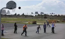  ??  ?? Students at the Quileute Tribal School play basketball playground as the Pacific Ocean waves crash just yards away in the Quileute community of La Push, Washington. Photograph: Tony Overman/The Olympian/MCT via Getty Images