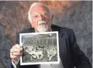  ?? JOURNAL SENTINEL FILES ?? Paul Melrood, shown here in 2009, holds a photo of himself with the 53rd Air Group at MacDill Air Field in Tampa, Florida.