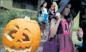  ?? Sergio Dionisio / Getty Images ?? Trick-or-treating children walk past a carved pumpkin Oct. 31, 2008, in Sydney, Australia. Americans are loading up on Halloween candy this year even as the status of normal festivitie­s is uncertain during the coronaviru­s pandemic.