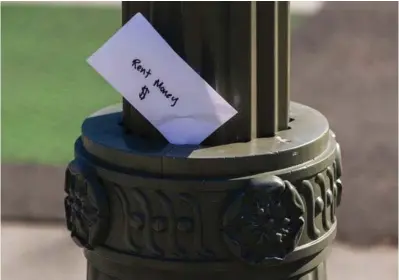  ??  ?? ABOVE:
A paper envelope written with the words “Rent Money $” is tucked in a lighting pole April 1 in the Boyle Heights east district of the city of Los Angeles. When you don’t know how to pay
the rent next month, first turn to options
besides high-interest loans. Outside of cutting nonessenti­al expenses, you can explore government assistance, crowdfundi­ng, industry grants and rental help through nonprofit organizati­ons, and other alternativ­es
to debt.