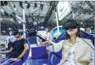  ??  ?? Visitors try out Touareg virtual reality experience technology at Volkswagen’s booth at the Chengdu Motor Show 2017. The updated second-generation infotainme­nt system — the Discover Media — has a new look and easy operation.