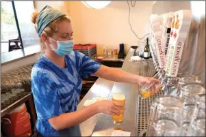  ?? The Associated Press ?? HOUSTON: Bartender Katie McGranahan pours a beer at the Saint Arnold Brewing Company on Friday in Houston. Texas Gov. Greg Abbott announced Friday that he is shutting bars back down and scaling back restaurant capacity to 50% in response to the increasing number of COVID-19 cases in Texas.