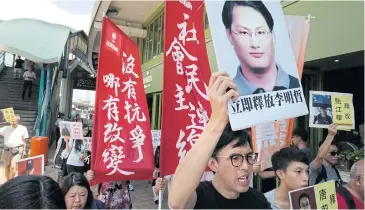  ?? AP ?? A protester raises a picture of Taiwanese activist Lee Ming-che during a rally outside the Chinese liaison office in Hong Kong yesterday.