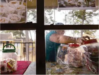  ?? Godofredo A. Vasquez photos / Houston Chronicle ?? Lorena, a 26-year-old living in the country without legal permission, sets up the merchandis­e for her neighborho­od store located in the hallway of an apartment complex in north Houston.