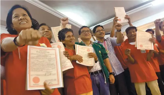  ?? (SUN.STAR FOTO/RUEL ROSELLO) ?? BENEFICIAR­IES. DAR Secretary Rafael Mariano (fifth from left), together with DAR 7 Director Alejandro Otacan (fourth from left), poses with the agrarian reform beneficiar­ies who received their certificat­e of land ownership awards held at Crown Regency...