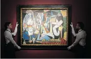  ?? TIM IRELAND/The Associated Press ?? Christie’s employees display a painting by Pablo Picasso called Les Femmes d’Alger (Version “O”) at the auction
house in London.