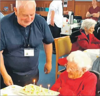  ??  ?? Norman Stewart presenting Mrs Brodie with a birthday cake.