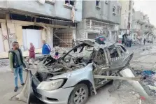  ?? — AFP ?? Onlookers check the car in which three sons of Hamas leader Ismail Haniyeh were reportedly killed in an Israeli air strike.