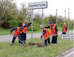  ?? ?? CHANGES — Municipal workers change Ukrainian road signs to Russian outside the city of Mariupol in this handout photo released by the Donetsk People Republic Ministry of transport on May 5, 2022. (AFP PHOTO/ Donetsk People Republic Ministry of transport)