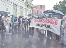  ??  ?? A pesar de la intensa lluvia, los usuarios de Catastro se manifestar­on frente a la sede de Hacienda.