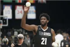  ?? THEMBA HADEBE — THE AP FILE ?? Team Africa’s Joel Embiid, of the 76ers, throws balls to fans during the NBA Africa Game over the summer in Pretoria, South Africa. The NBA has big plans to make a ‘longterm play’ Africa.