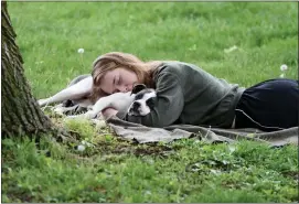  ?? PAM PANCHAK/ PITTSBURGH POST-GAZETTE VIA AP, FILE ?? A woman and her dog nap between rain showers at Schenley Park, Tuesday, May 4, 2021 in Pittsburgh.