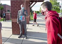  ?? SARAH GORDON/THE DAY ?? Principal Jason Bitgood wears a photo of himself Monday so students recognize him behind his mask.