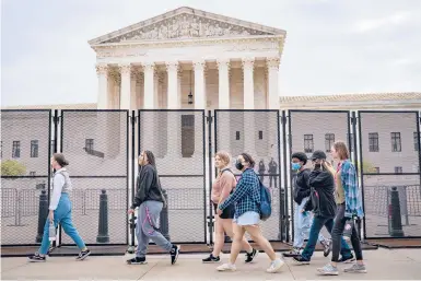  ?? PETE MAROVICH/THE NEW YORK TIMES ?? High school students pass a fence around the Supreme Court building last week in Washington.