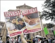  ?? DEBORAH CANNON / AMERICAN-STATESMAN ?? An advocate for restoratio­n of state education funding levels thatwere cut in 2011 and newevaluat­ion of standardiz­ed testing holds up signs at a Save Texas Schools rally at the Capitol in April.