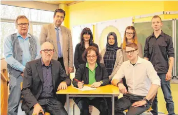  ?? FOTO: WR ?? Unter den Augen von Konrad Schmidt, Stephan Wohlgemuth, den Azubis Celine Weissbeck, Fatima Kayacan, Lena Amann und Dominik Besanowsky (hintere Reihe von links) unterzeich­neten Christoph Merschhemk­e, Alexandra Maier-Lipp und Marktleite­r Marc Billerbeck...