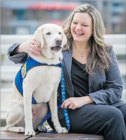  ?? RIC ERNST/PNG ?? Victim services worker Kim Gramlich hugs Caber, an accredited assistance dog who provides support to victims and witnesses of trauma and crime. Caber’s success with Delta Police prompted other police department­s across Canada to employ trauma dogs.