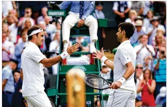  ?? CLIVE BRUNSKILL PHOTOS / GETTY IMAGES ?? Novak Djokovic of Serbia shakes hands with Roger Federer of Switzerlan­d at the net after victory in his Men’s Singles final during The Championsh­ips - Wimbledon 2019 at All England Lawn Tennis and Croquet Club on Sunday in London, England.