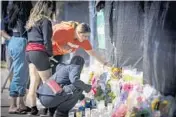  ?? ROBERT BUMSTED/AP ?? Stacey Sarmiento places flowers at a makeshift memorial in honor of a friend Sunday in Houston.