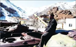  ?? WAKIL KOHSAR/AFP ?? An Afghan man sits on the remains of Soviet-era tanks along a road in Saricha of Bazarak District in Panjshir Province, north of the capital Kabul.