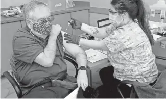  ?? MIKE DE SISTI / MILWAUKEE JOURNAL SENTINEL ?? Jim Myers, 71, of Franklin receives the COVID-19 vaccine from Haley Peronto at the Ascension SE Wisconsin Hospital Franklin Campus on Jan. 25.