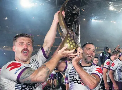  ?? PHOTO: GETTY IMAGES ?? The Cam show . . . Storm captain Cameron Smith (right) and teammate Cameron Munster hold the premiershi­p trophy after their side’s win in the NRL grand final at ANZ Stadium in Sydney on Sunday night.