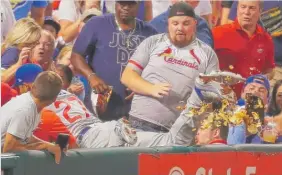  ?? | GETTY IMAGES ?? Fans in the front rowhave gone viral at two recent Cubs games. First, therewas the fan who lost his nachos when Addison Russell dove for a foul ball Sept. 25 in St. Louis. Then came the fan who caught Anthony Rizzo’s home- run ball Saturday.