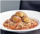  ??  ?? The pairing of spaghetti and crab balls is one of those quirky Baltimore combinatio­ns that somehow works.
