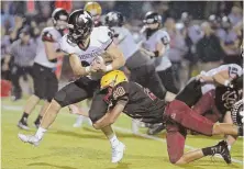  ?? STAFF PHOTO BY STUART CAHILL ?? HOLD ON TIGHT: BC High safety Nate Stewart (20) grabs ahold of Marshfield’s Casey Phinney as the Rams runner drives for extra yards last night in Dorchester.