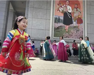  ?? — AFP/AP ?? Nuclear-powered submarine ‘USS Michigan’ (left) arriving at the port city of Busan, South Korea, as a young girl takes part in a mass dance in Pyongyang, North Korea.