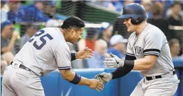  ?? AP ?? Luke Voit (r.) is met by teammate Gleyber Torres after hitting a home run against the Blue Jays during the sixth inning on Saturday afternoon in Toronto.