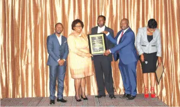  ??  ?? Guest of Honour congratula­ting Vice Chancellor Professor Wiseman Magwa and Council Chairman Dr Augustine Mazvuru on the University of the Year Award