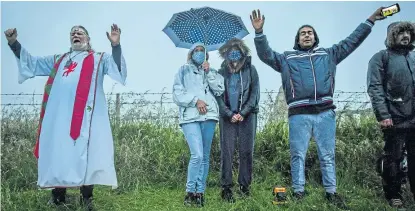  ?? Picture: PA. ?? People celebrate the dawn next to a closed Stonehenge.