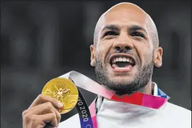  ?? Francisco Seco The Associated Press ?? Lamont Marcell Jacobs shows off his gold medal following the 100-meter final at the Summer Olympics in Tokyo in 2021.