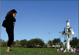  ?? Washington Post photo by Matt McClain ?? Katiusca Dulski cries as she visits a makeshift memorial in Pine Trails Park for the victims of the Marjory Stoneman Douglas High School shooting victims on Friday Feb. 16, in Parkland, Florida. There was a cross in the park for each victim.