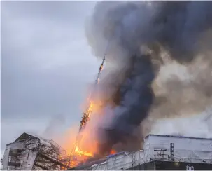  ?? (Ritzau Scanpix/Ida Marie Odgaard via Reuters) ?? THE TOWER of the Old Stock Exchange, Boersen in Copenhagen collapses after a fire in the old building yesterday.