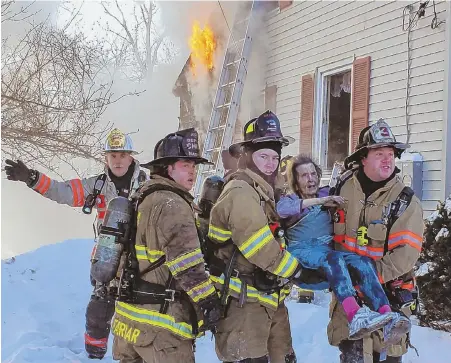  ?? HERALD PHOTO BY PATRICK KERRIGAN ?? A DIFFICULT RESCUE: Firefighte­rs in Nashua, N.H., carry an elderly woman from a home during a two-alarm fire on Lock Street yesterday.