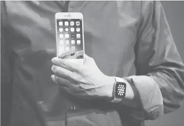  ?? — AFP photo ?? Cook shows off the new iPhone 6 and the Apple Watch during an Apple special event at the center for the Performing Arts.