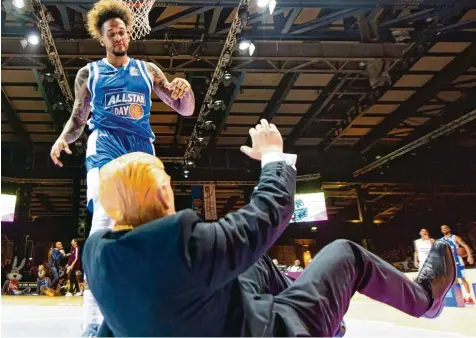  ?? Foto: dpa ?? Julian Gamble hat den Ball in den Korb gestopft, das Trump Double geht zu Boden. Der Profi von den Bonner Telekom Baskets nutzte das Allstar Spektakel in Göttingen zu einer Polit Inszenieru­ng.